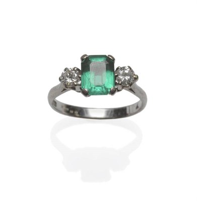 Lot 1094 - A Synthetic Emerald and Diamond Three Stone Ring, the emerald-cut emerald flanked by a round...