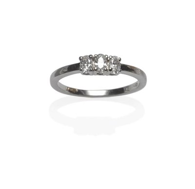 Lot 1109 - A Platinum Diamond Three Stone Ring, the oval cut diamonds in claw settings, to a plain...