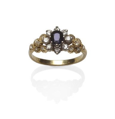 Lot 1137 - A Contemporary Sapphire and Diamond Cluster Ring, the oval mixed cut sapphire within a border...