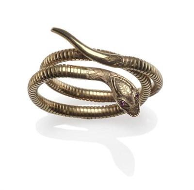 Lot 1150 - A 9 Carat Gold Snake Bangle, with engraved head and tail, garnet eyes, and a steel spring core