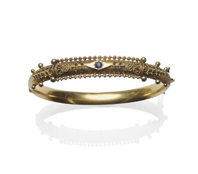 Lot 1154 - A 9 Carat Gold Sapphire Set Bangle, the rope twist and bead decorated front with a sapphire set...