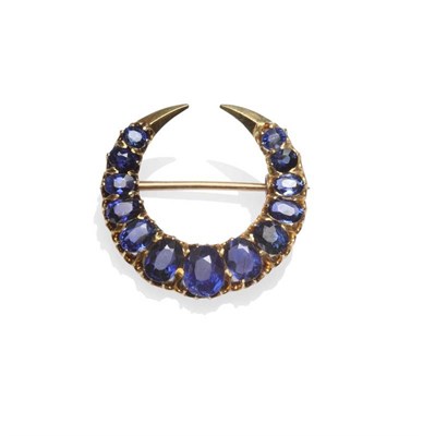 Lot 1201 - An Early 20th Century Crescent Brooch, set with graduated oval cut sapphires, in yellow claw...