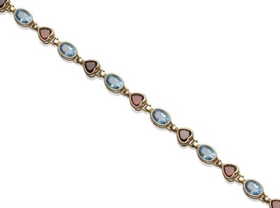 Lot 1076 - A Blue Topaz and Garnet Bracelet, the heart shaped garnets alternate with oval cut topaz, in yellow