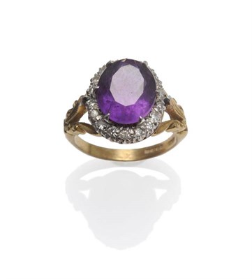 Lot 1098 - An 18 Carat Gold Amethyst and Diamond Cluster Ring, the oval cut amethyst within a border of...