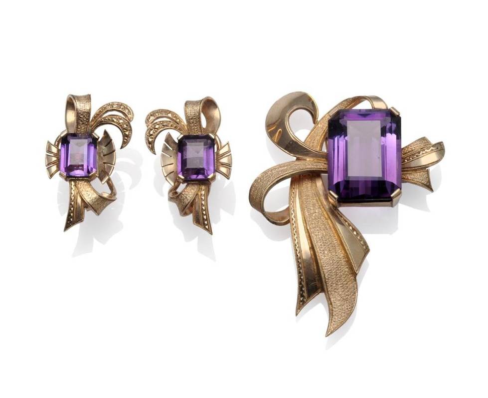 Lot 1100 - A Mid 20th Century Amethyst Brooch, an emerald cut amethyst in a yellow four claw setting, within a