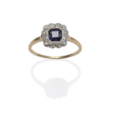 Lot 1111 - A Sapphire and Diamond Cluster Ring, the octagonal step cut sapphire within a border of...