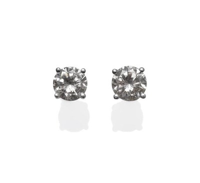 Lot 1154 - A Pair of Diamond Solitaire Stud Earrings, the round brilliant cut diamonds in white four claw...