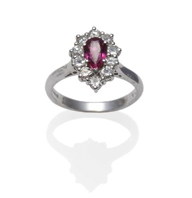 Lot 1102 - An 18 Carat White Gold Ruby and Diamond Cluster Ring, the pear cut ruby within a border of...