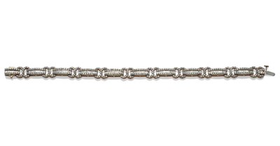 Lot 1103 - A 9 Carat Gold Fancy Link Diamond Bracelet, the links with graduated baguette cut diamonds...