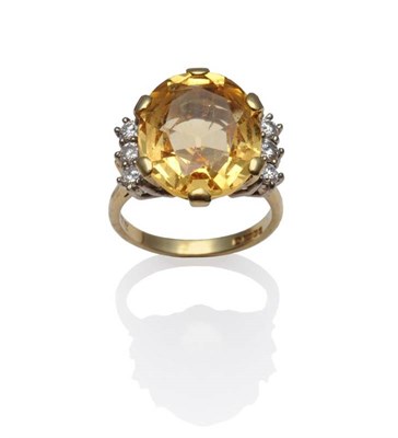 Lot 1109 - An 18 Carat Gold Topaz and Diamond Ring, the golden yellow oval mixed cut topaz within a yellow six