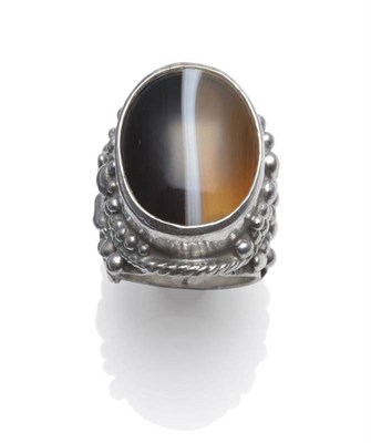 Lot 1128 - A Silver Agate Ring, by Michael Bolton, a large oval sardonyx in a silver collet setting with...