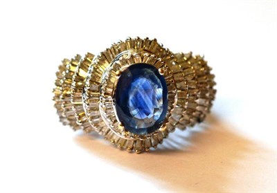 Lot 1134 - A Sapphire Doublet and Diamond Cluster Ring, the oval mixed cut doublet in a white four claw...