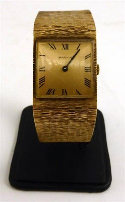 Lot 1136 - A 9ct Gold Wristwatch, signed Marvin, 1970, lever movement, champagne coloured dial with Roman...