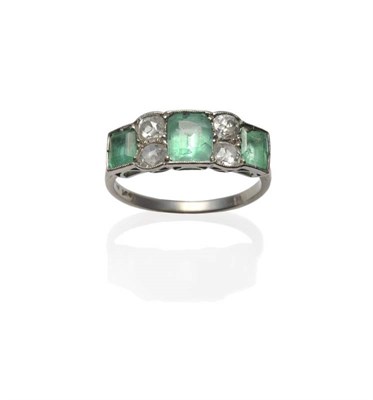 Lot 1161 - An Emerald and Diamond Ring, the three graduated step cut emeralds alternate with pairs of old...