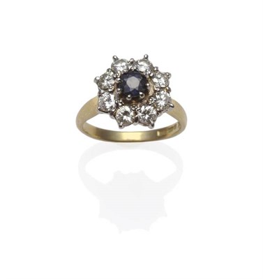 Lot 1172 - An 18 Carat Gold Sapphire and Diamond Cluster Ring, the round cut sapphire within a border of round