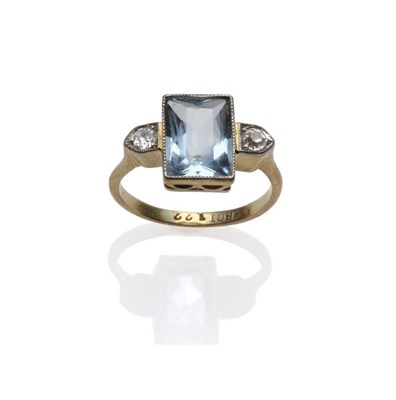 Lot 1177 - An 18 Carat Gold Aquamarine and Diamond Three Stone Ring, a scissor cut aquamarine within two...