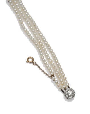 Lot 1209 - A Three Row Pearl Choker, the button shaped (probably freshwater) pearls strung to a diamond...