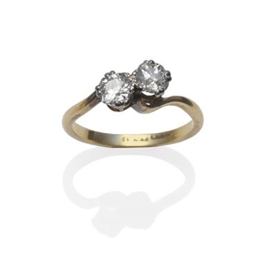 Lot 1211 - A Diamond Two Stone Twist Ring, the old cut diamonds in white claw settings on a yellow twist...