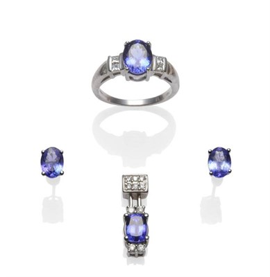 Lot 1231 - An 18 Carat White Gold Tanzanite and Diamond Ring, the oval cut tanzanite in a white claw...