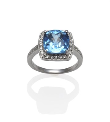 Lot 1115 - An 18 Carat White Gold Blue Topaz and Diamond Cluster Ring, a fancy rose cut blue topaz within...