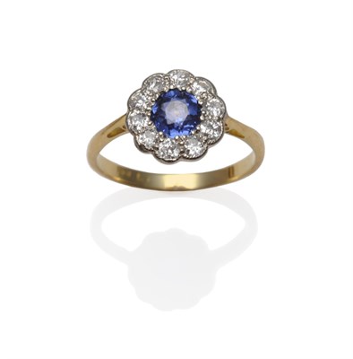 Lot 1138 - A Sapphire and Diamond Ring, the round brilliant cut sapphire within a border of ten round...