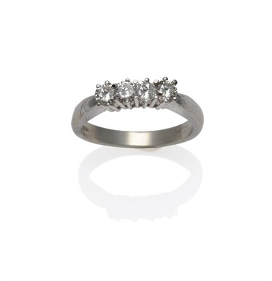 Lot 1152 - An 18 Carat White Gold Diamond Four Stone Ring, the round brilliant cut diamonds in claw...