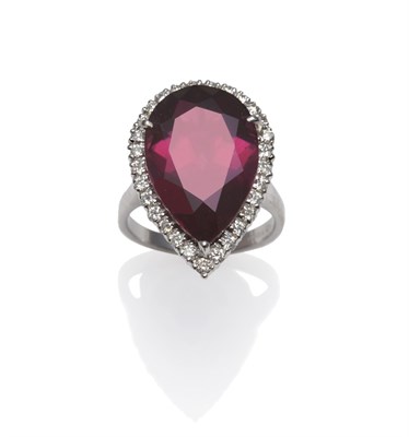Lot 1156 - An 18 Carat White Gold Garnet and Diamond Ring, the pear cut garnet within a border of round...