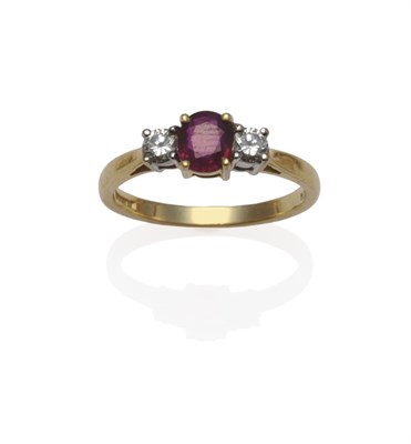 Lot 1176 - An 18 Carat Gold Ruby and Diamond Three Stone Ring, an oval mixed cut ruby flanked by a round...