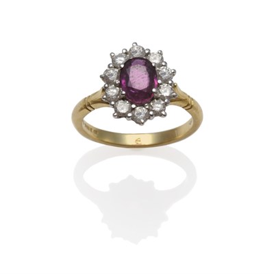 Lot 1181 - An 18 Carat Gold Ruby and Diamond Cluster Ring, an oval mixed cut ruby within a border of ten round