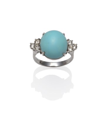 Lot 1220 - A 14 Carat White Gold Turquoise and Diamond Ring, the oval cabochon turquoise flanked by a trio...