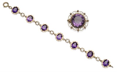 Lot 1236 - An Amethyst Brooch, the round cut amethyst within a scrolling and beaded frame, measures 3cm in...