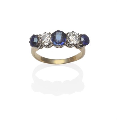 Lot 1240 - A Sapphire and Diamond Five Stone Ring, three graduated sapphires alternate with two old cut...