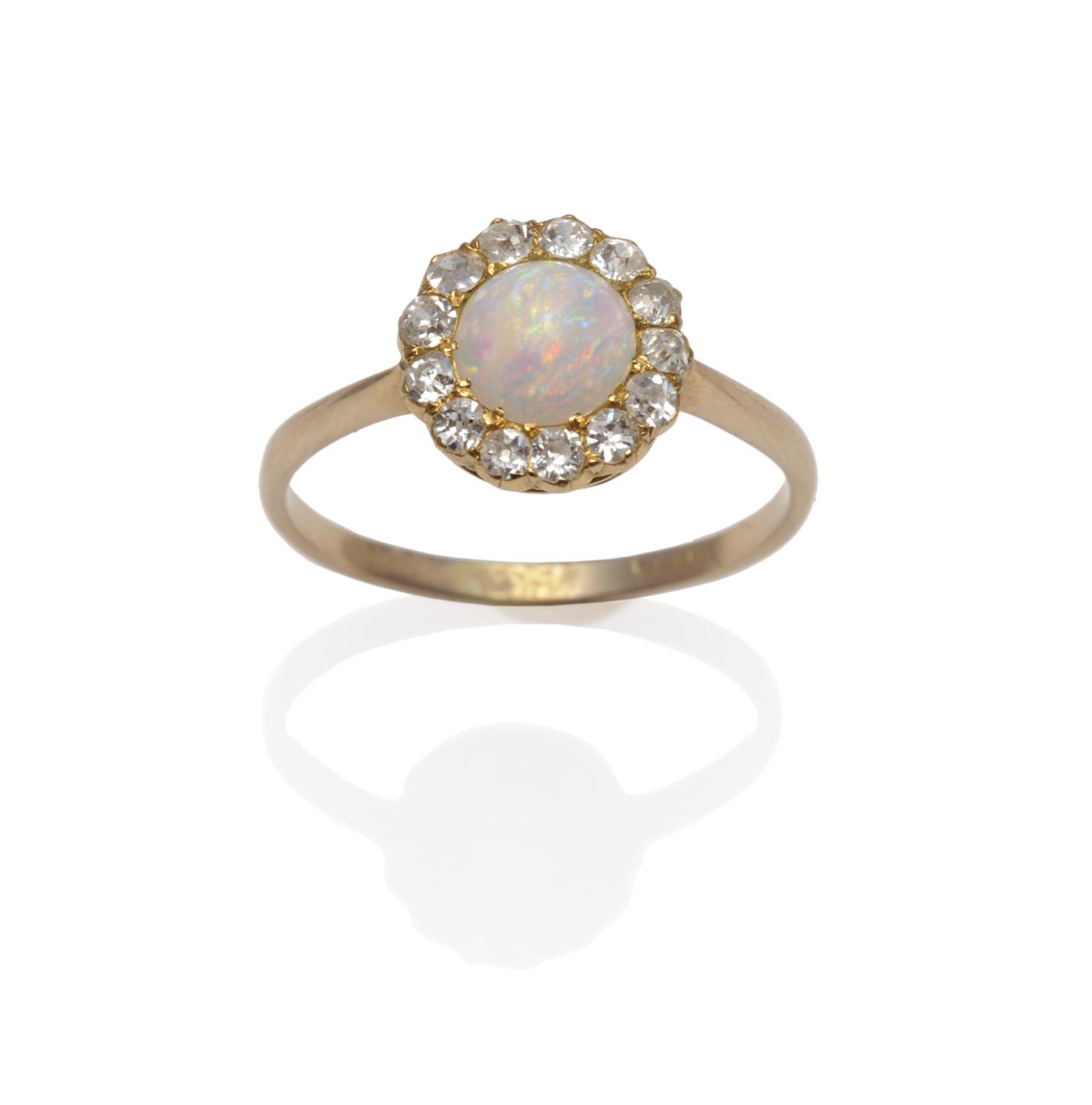 Lot 1243 - An Opal and Diamond Cluster Ring, the round cabochon opal within a border of thirteen old cut...