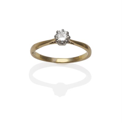Lot 1246 - A Diamond Solitaire Ring, the round brilliant cut diamond in a white claw setting on a yellow...