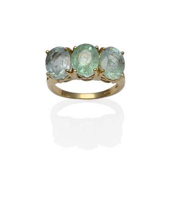 Lot 1257 - An 18 Carat Gold Tourmaline Three Stone Ring, the bluey-green oval mixed cut tourmalines in...