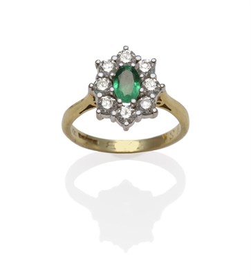 Lot 1262 - An 18 Carat Gold Emerald and Diamond Cluster Ring, an oval cut emerald within a border of round...
