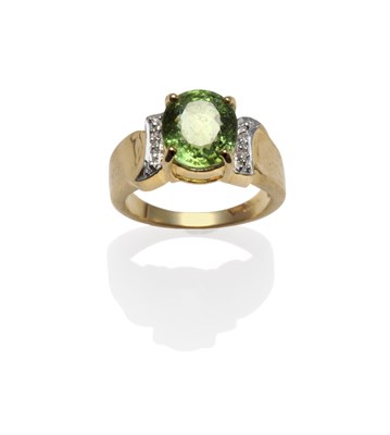 Lot 1267 - An 18 Carat Gold Tourmaline and Diamond Ring, the oval mixed cut green tourmaline in a yellow...