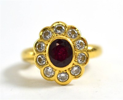 Lot 1270 - A Ruby and Diamond Cluster Ring, the oval mixed cut ruby within a border of ten round brilliant cut