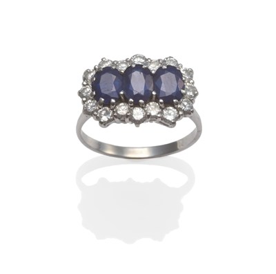 Lot 2025 - A Sapphire and Diamond Triple Cluster Ring, three oval cut sapphires within a border of round...