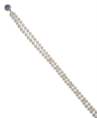 Lot 2027 - A Two Row Cultured Pearl Necklace, the pearls knotted with diamond set spacers to the front section