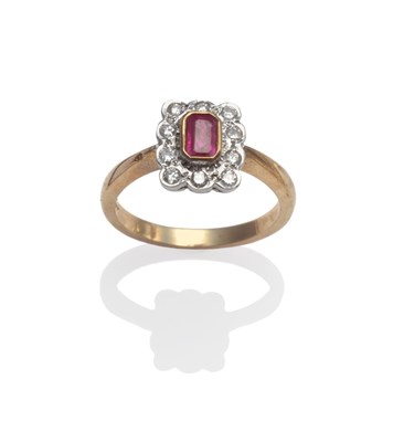 Lot 2079 - A 9 Carat Gold Ruby and Diamond Cluster Ring, the emerald-cut ruby in a yellow rubbed over setting