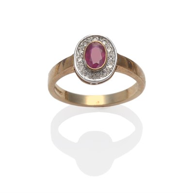 Lot 2088 - A 9 Carat Gold Ruby and Diamond Cluster Ring, the oval cut ruby in a yellow collet setting within a