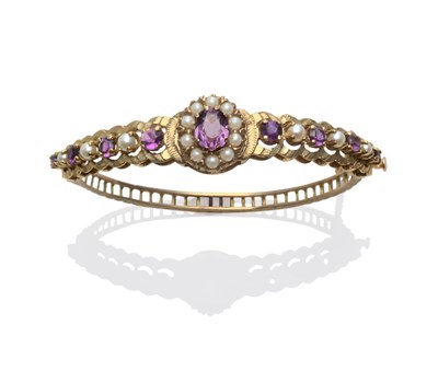 Lot 2094 - A 9 Carat Gold Bangle, set with amethysts and cultured pearls in a decorative mount, hinged to...