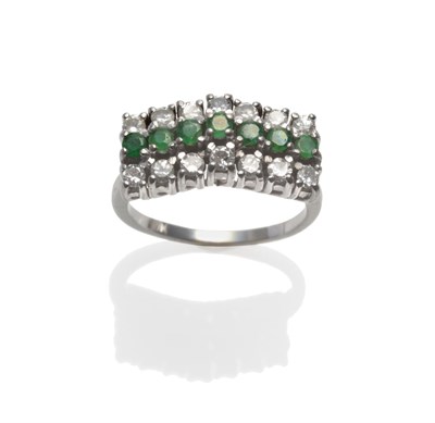 Lot 2124 - An Emerald and Diamond Ring, a row of round cut emeralds flanked by a row of round brilliant...
