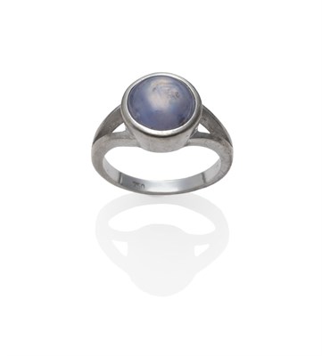 Lot 2131 - A Star Sapphire Ring, the round cabochon sapphire in a white collet setting to a forked...