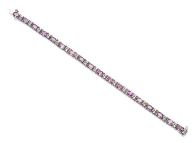 Lot 2041 - A Pink Sapphire and Diamond Bracelet, oval cut pink sapphires spaced by pairs of round...