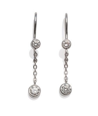 Lot 2046 - A Pair of Diamond Drop Earrings, a collet set round brilliant cut diamond suspends a chain...