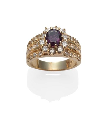 Lot 2049 - A Ruby and Diamond Cluster Ring, the oval mixed cut purpley-red ruby within a border of round...