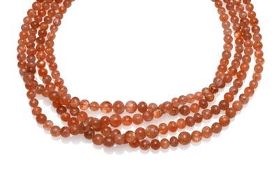 Lot 2066 - A Sunstone Necklace, four strands of graduated sunstone beads strung to a fabric tie