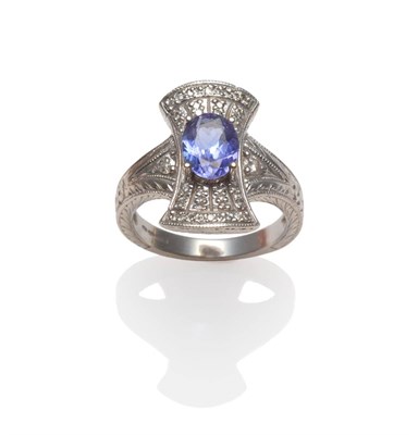 Lot 2067 - A 14 Carat White Gold Tanzanite and Diamond Cluster Ring, an oval cut tanzanite within a plaque...